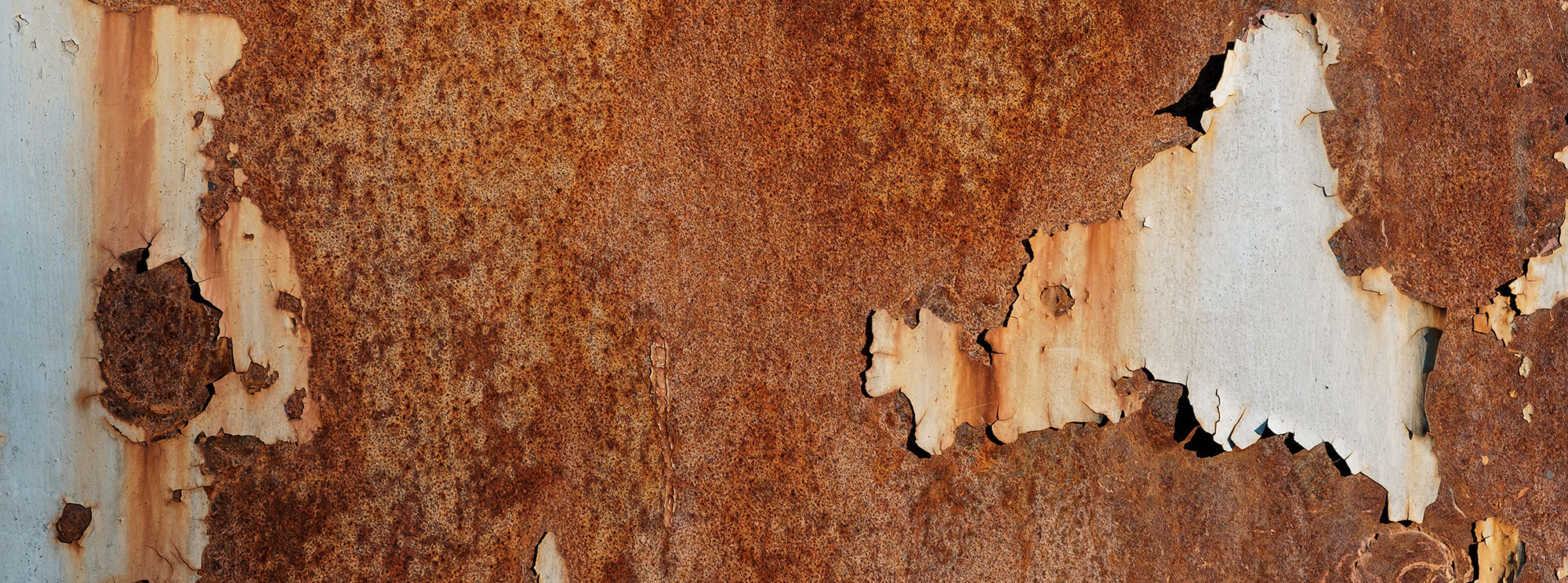 Rostige Metalloberfläche mit Spuren von abblätternder grauer Farbe. 